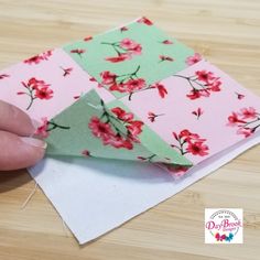 someone is cutting out the fabric on top of each other to make an origami flower