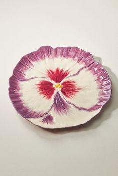 a purple and white flower shaped dish on a table