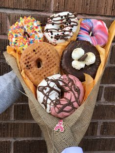 a bunch of doughnuts that are in a bag on the ground next to a brick wall