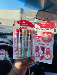 hello kitty lip smackers are in the car and someone is holding up their hand