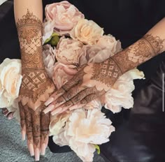 two hands with henna and flowers on them