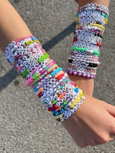 two girls wearing bracelets made out of letters and numbers on their wristbands