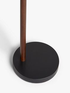 an umbrella stands on top of a black plate with a wooden pole in the middle