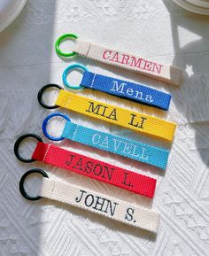 four personalized lanyards are sitting on a table with scissors in each one