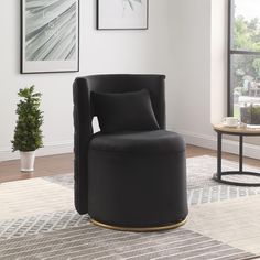 a black chair sitting on top of a rug in a living room next to a window