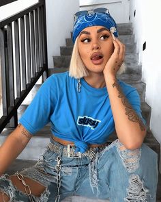 a woman with blonde hair and piercings sitting on the stairs talking on her cell phone