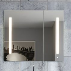 a bathroom mirror with lights above it and a sink in front of the mirror on the wall