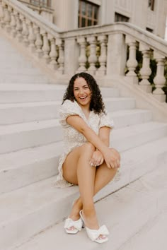 a woman is sitting on the steps smiling