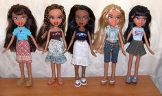 five dolls are lined up on a shelf