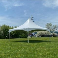 a large white tent sitting on top of a lush green field