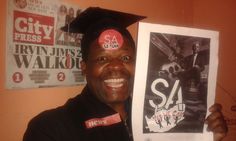 a man wearing a graduation cap holding up a poster with the word sa on it