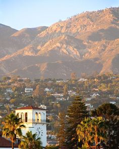 the mountains are in the distance with houses and palm trees on the foreground below