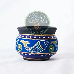 a blue bowl with fish painted on the side and a tree in the middle, sitting on a white surface