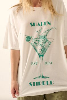 A vintage-style martini glass graphic print with "Shaken" "Stirred" and "EST 2024" text. Round neckline. Short sleeves. Dropped shoulder. Oversized fit. Torn and distressed detailing at neckline, cuffs, and hem. FINAL SALE, NO RETURNS Promesa Oversized fit Distressed graphic tee Model is 5'9 wearing size small. Wash cold separately, hang to dry Martini Graphic, Distressed Graphic Tee, Blue Zone, Activewear Sets, Martini Glass, Skirt Leggings, Layered Look, Jean Leggings, Plus Size Tops