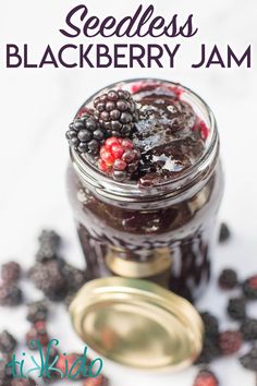 a jar filled with blackberries and jam on top of a table