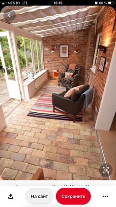 a living room with brick walls and flooring in the center, two couches are facing each other