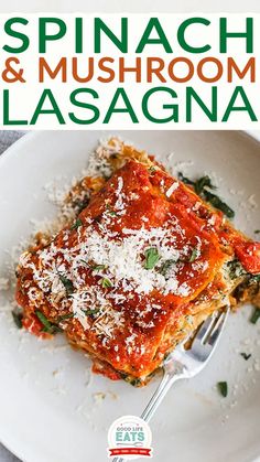 spinach and mushroom lasagna on a white plate with a fork in it