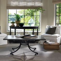 a living room with two chairs and a coffee table in front of the couches