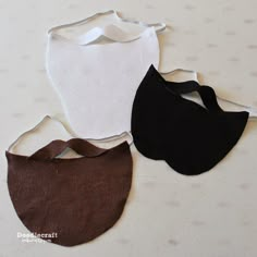 three pieces of cloth are laid out on a white surface, one is brown and the other is black