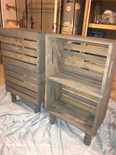 two wooden crates sitting on top of a white sheeted floor next to each other