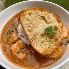 a white bowl filled with shrimp and grits on top of rice covered in gravy