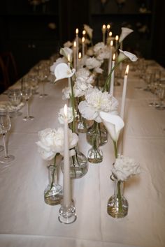 a long table with white flowers and candles