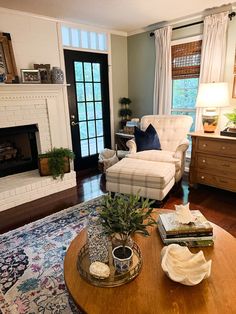 a living room filled with furniture and a fire place under a window next to a fireplace