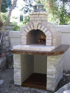 an outdoor brick pizza oven built into the side of a wall