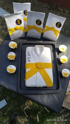 a table topped with cake and cupcakes covered in yellow ribbon