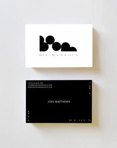 two black and white business cards sitting on top of each other next to one another