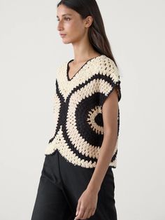 a woman in black and white crocheted sweater