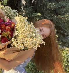 a woman is holding flowers in her hands