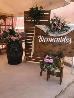 a wooden sign that says beneveendos with flowers on it and two stools