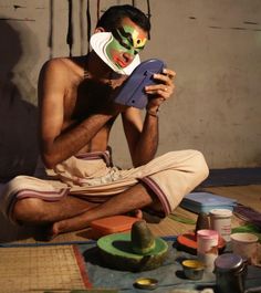 a man sitting on the floor with his face painted