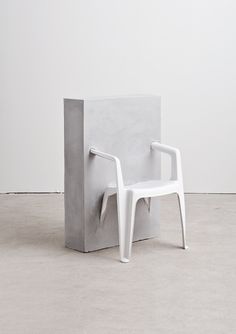 a white plastic chair sitting in front of a cement block with the word instagram on it