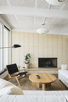 a living room filled with furniture and a fire place in front of a large window