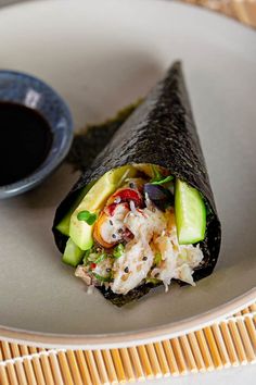 a white plate topped with a burrito covered in toppings next to a cup of coffee