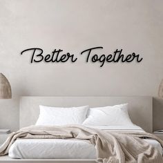 a bedroom with a bed and two lamps on the wall next to it is decorated with metal letters that spell out better together