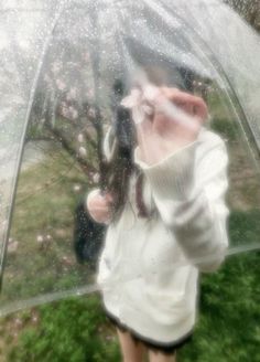 a woman standing under an umbrella in the rain