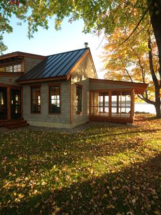 an image of a small house in the middle of some grass with trees around it