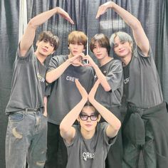 a group of young men standing next to each other with their hands in the air