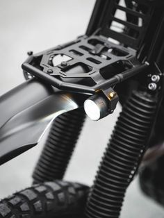 a close up of the front end of a motorcycle with its light on and handlebars down