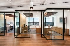 an office with glass walls and wooden floors