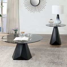 two black tables with glass tops in front of a white wall and flooring area