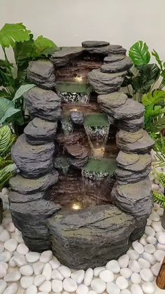 a water fountain surrounded by rocks and plants