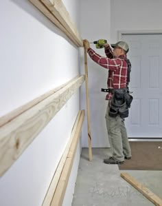 a man is working on the wall in his house