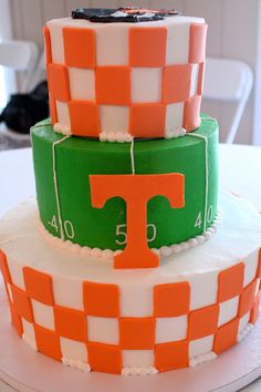 three tiered cake decorated with orange, white and green squares