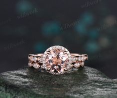 an engagement ring with a pink morganite surrounded by diamonds on top of a rock