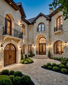 a large house with lots of windows and stone walkway leading to the front door area