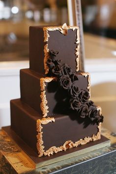 a three tiered chocolate cake with flowers on top